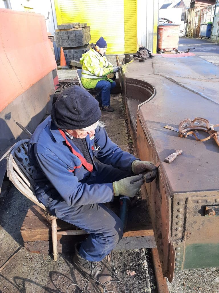 ed Tatham and John Davis work on the bottom of one of 5643's side tanks.